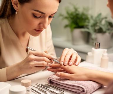 Martina, nail designer, mentre rifinisce una manicure elegante con strumenti professionali